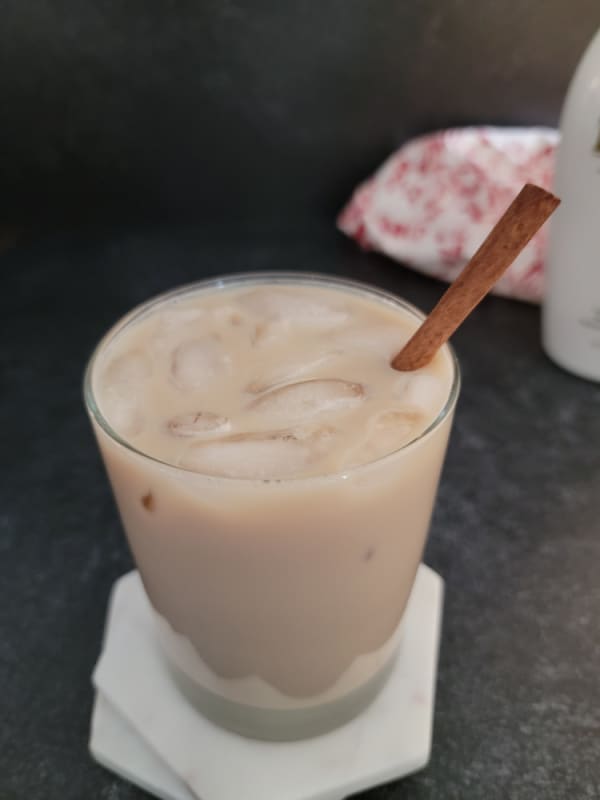 Iced RumChata Coffee with a cinnamon stick in a clear glass