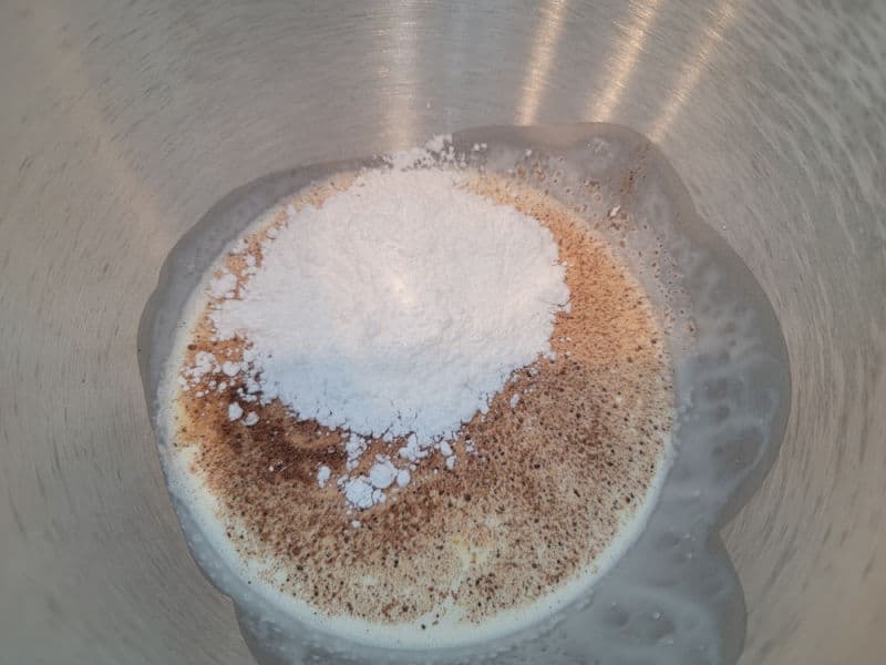 Eggnog whipped cream ingredients in the bottom of a silver mixing bowl