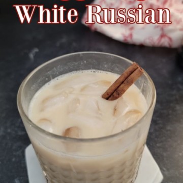 Eggnog White Russian text over a cocktail glass garnished with a cinnamon stick