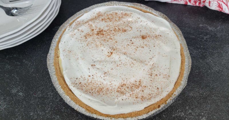 No bake eggnog pie with a graham cracker crust on a dark counter