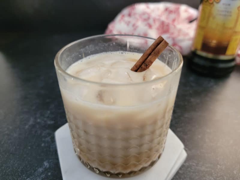 White Russian Cocktail with Eggnog in a crystal glass garnished with a cinnamon stick