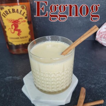 Fireball Eggnog text next to a bottle of fireball and a glass filled and garnished with a cinnamon stick