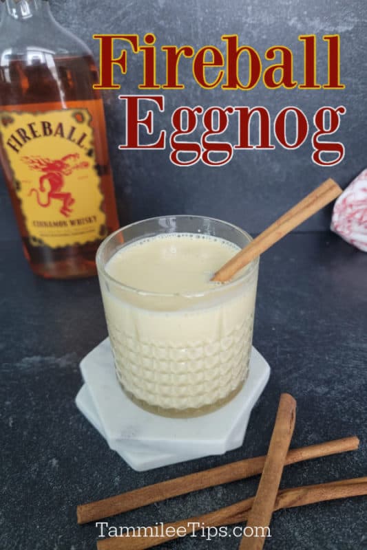 Fireball Eggnog over a bottle of eggnog, glass with drink, and cinnamon sticks. 