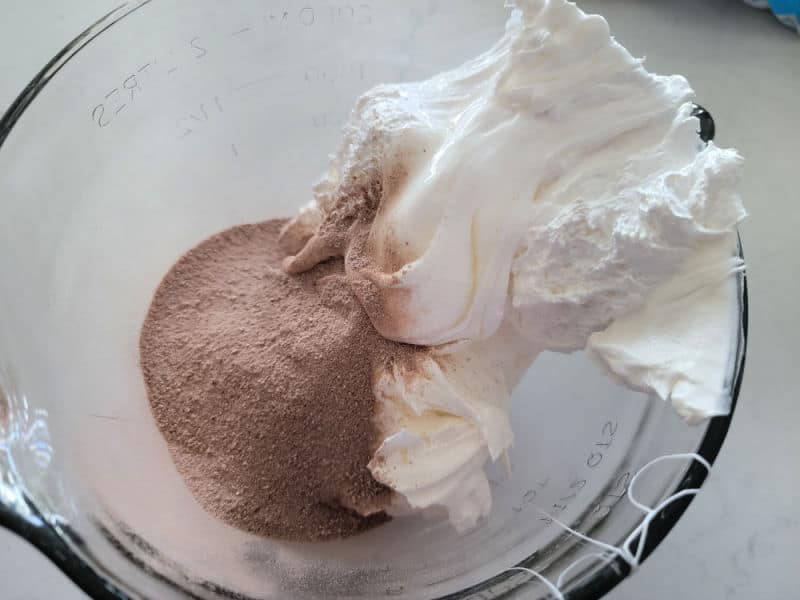 Hot Chocolate dip ingredients in a clear glass bowl before mixing