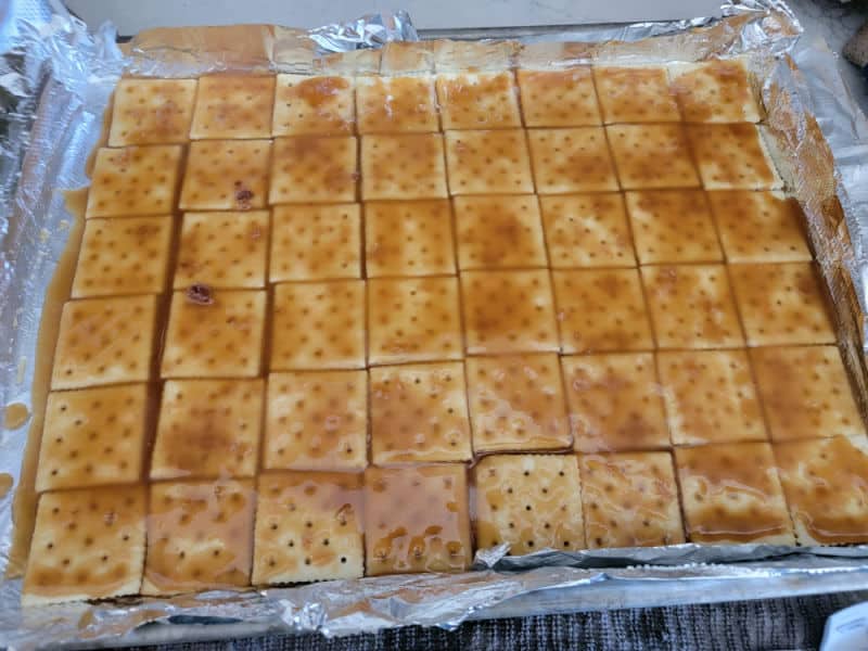 Toffee mixture spread over Saltines to make Christmas Crack