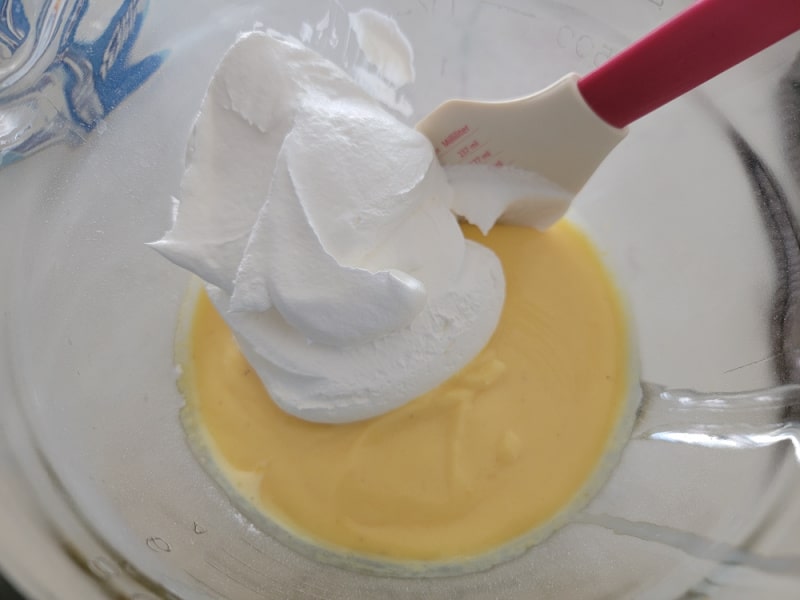 Cool whip on top of eggnog pie mixture in a glass bowl
