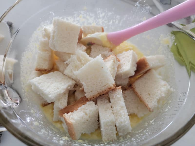 white bread in a glass bowl with butter mixture for pineapple stuffing. 
