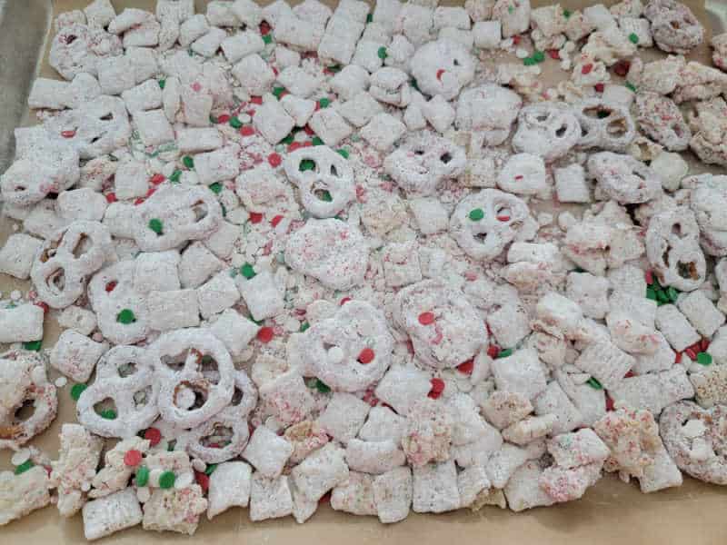 Reindeer Chow spread on a parchment-lined baking sheet