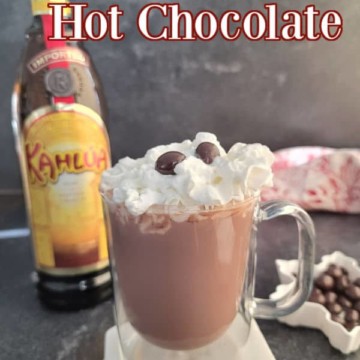 Kahlua Hot Chocolate text over a glass coffee mug with kahlua hot chocolate whipped cream and an espresso bean