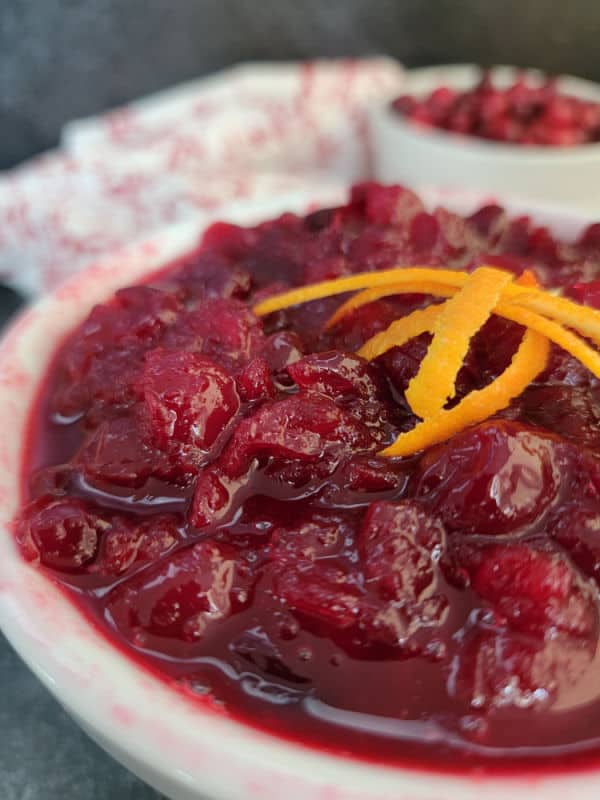 Cranberry sauce in a white bowl with orange zest