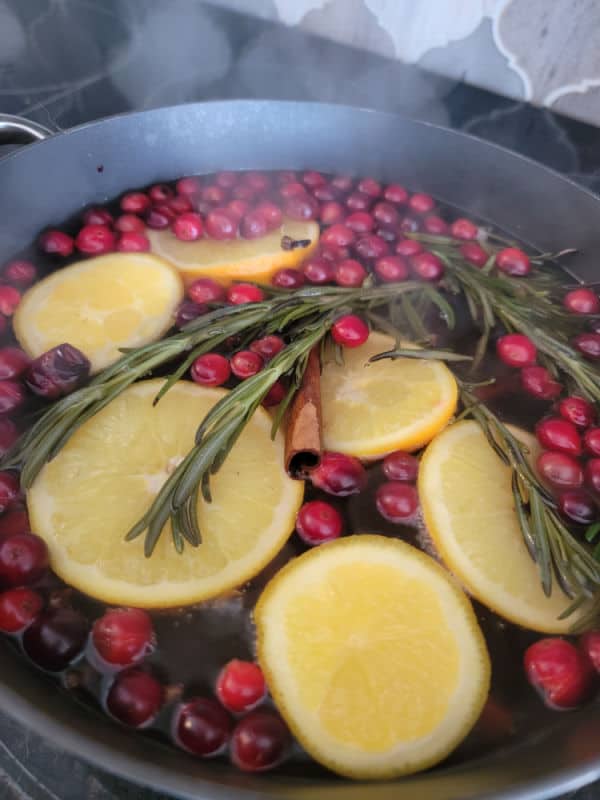 cranberries, rosemary, cinnamon sticks, and orange wheels simmering for Christmas Potpourri