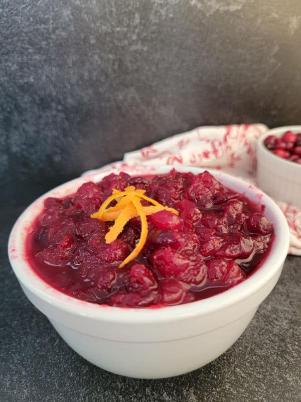 Cranberry sauce in a white bowl with orange zest