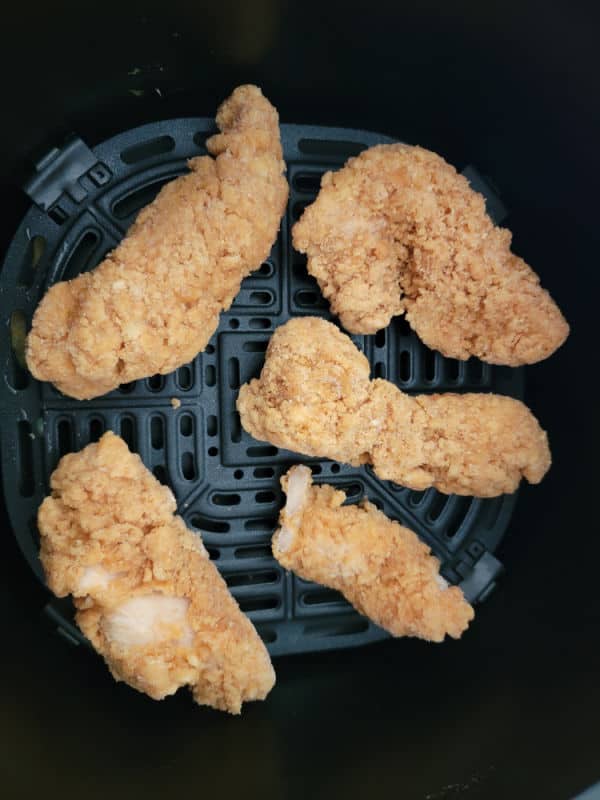 Chicken strips in an air fryer basket