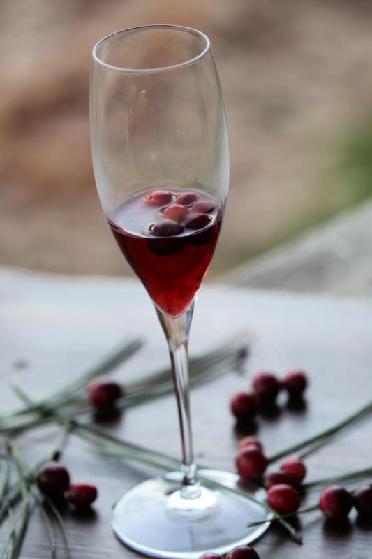 Cranberry Juice and fresh cranberries in a champagne flute for Cranberry Mimosas