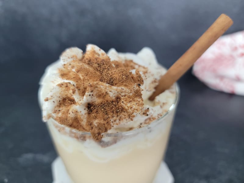 Eggnog Mudslide topped with whipped cream, ground nutmeg, with a cinnamon stick