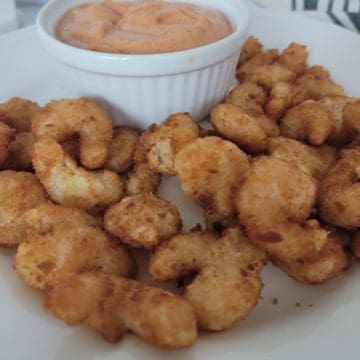 air fried shrimp on a white plate next to a bowl of sauce