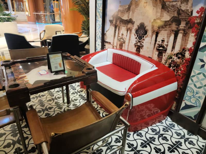 Replica car seat turned into a couch near a game table and additional chairs