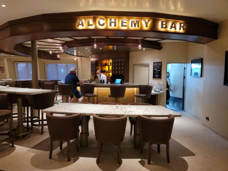 Alchemy Bar sign over the bar with tables and chairs