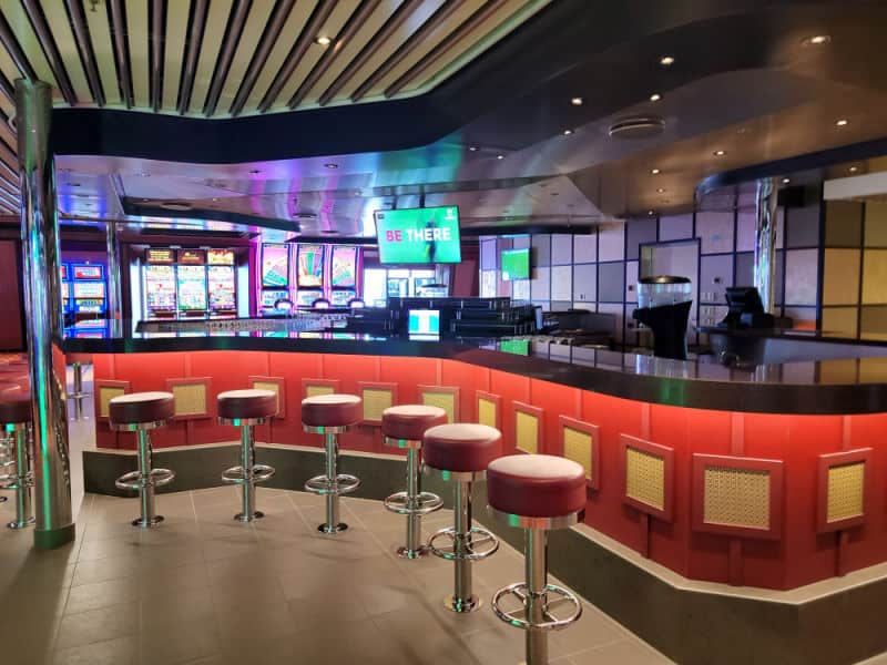 curved bar with stools and slot machines in the background