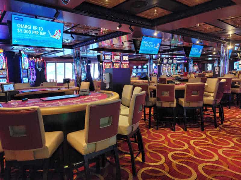casino tables and chairs with TVs above them