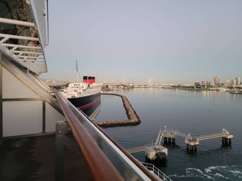 historic ship next to the cruise ship looking down from the balcony