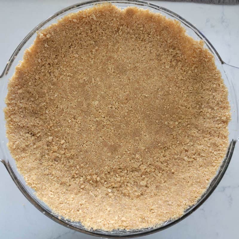 Graham cracker crust in a glass baking dish