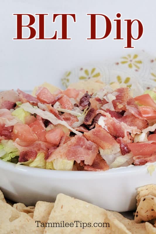 BLT Dip over a white bowl with bacon, lettuce, tomatoes next to tortilla chips