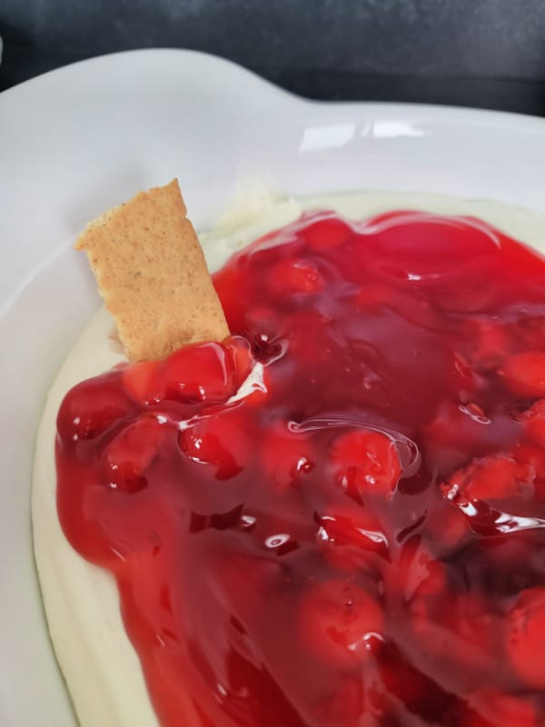 No Bake Cherry cheese cake dip in a white serving bowl with a graham crackers
