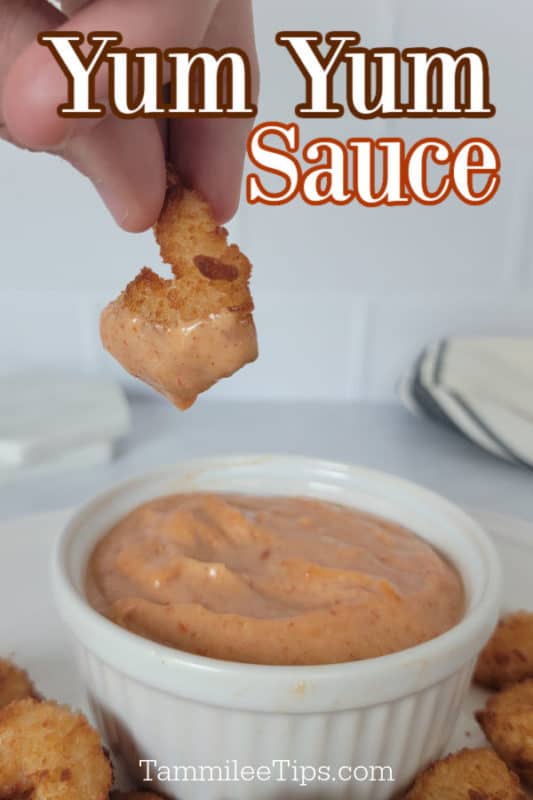 Yum Yum Sauce text written over a hand dipping a fried shrimp in a bowl of homemade yum yum sauce