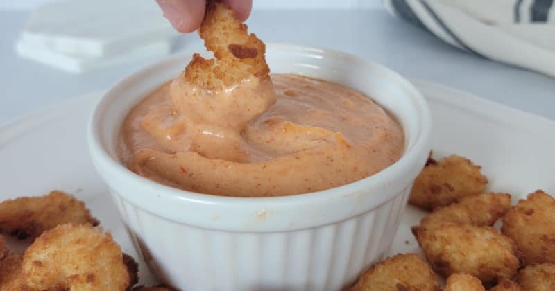 Shrimp dipping into Yum Yum Sauce in a white bowl