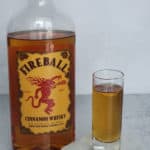 Fireball shot in a glass next to a bottle of Fireball