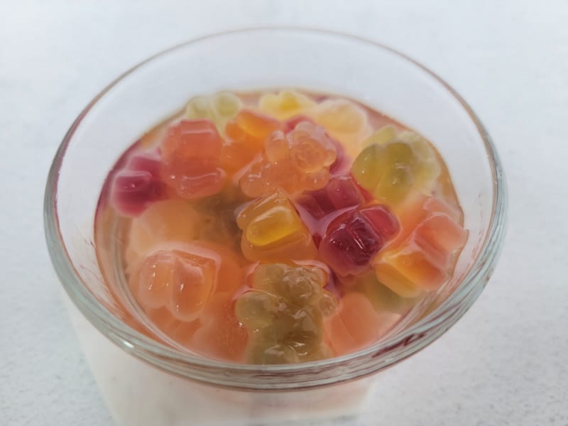 Gummy bears in a glass bowl with clear liquid