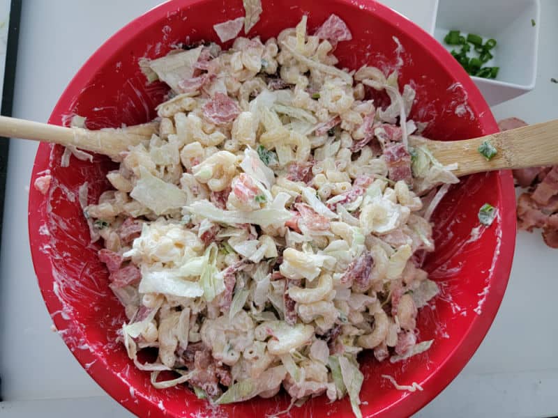 BLT Macaroni Salad in a red bowl with wooden spoons