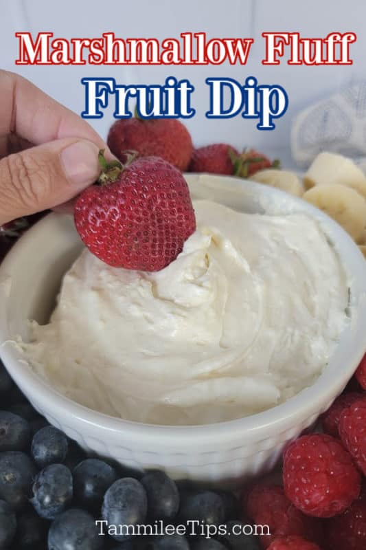 Marshmallow fluff fruit dip text written over a hand holding a strawberry dipping into Marshmallow Fruit dip surrounded by fresh fruit. 