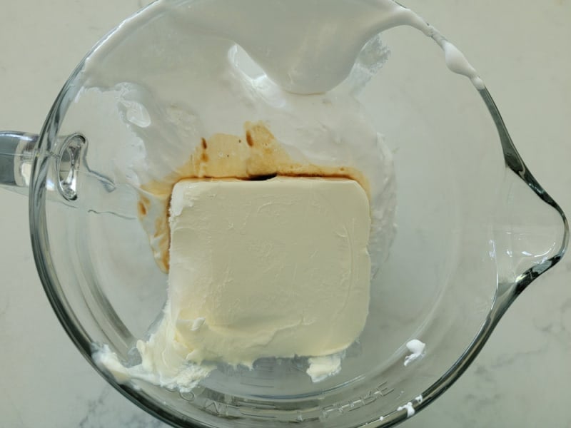 Cream cheese block and vanilla in a glass bowl for Marshmallow Fluff Fruit Dip