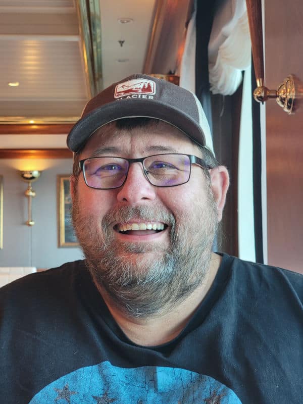 John smiling wearing a Glacier hat