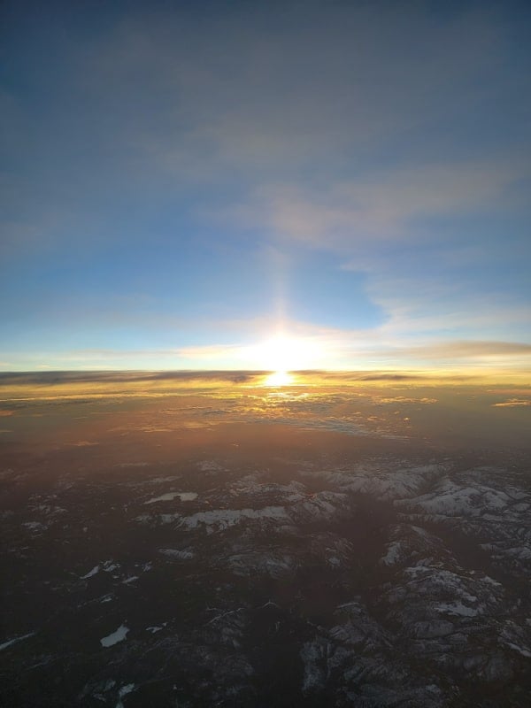 Sunrise from a plane over snowy mountains