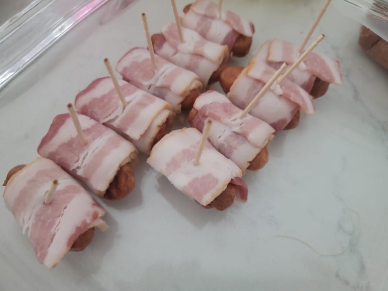 unbaked bacon wrapped little smokies with toothpicks holding them together