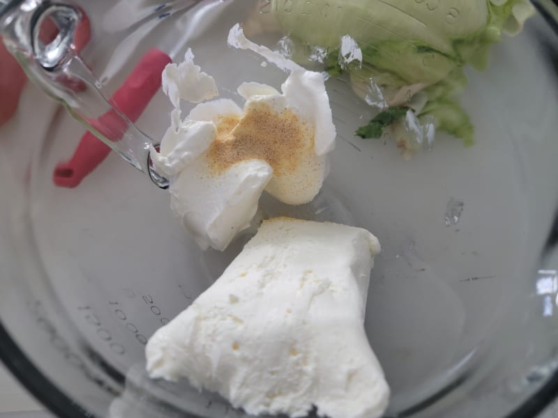 Cream cheese, sour cream, and garlic powder in a glass bowl 