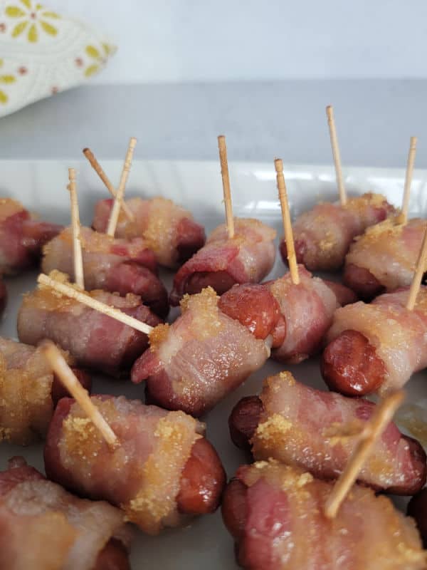Brown sugar bacon little smokies with a toothpick on a white platter