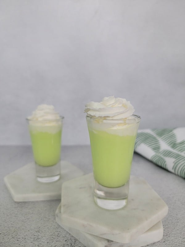 creamy green scooby snack shot with whipped cream garnish in a glass shot glass. 