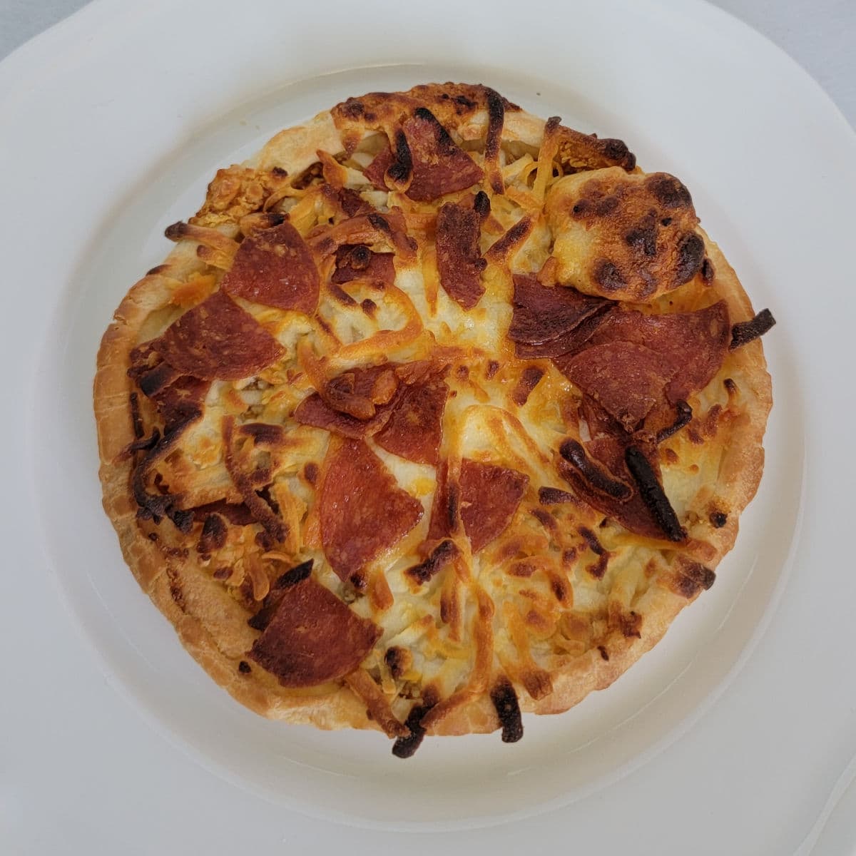 air fried pepperoni pizza on a white plate