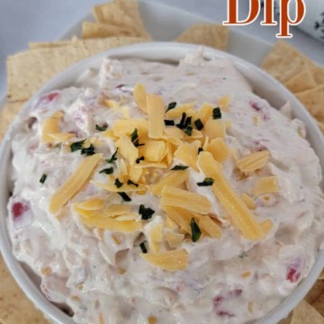 Fiesta Ranch Dip text over a white bowl with dip garnished in shredded cheddar cheese