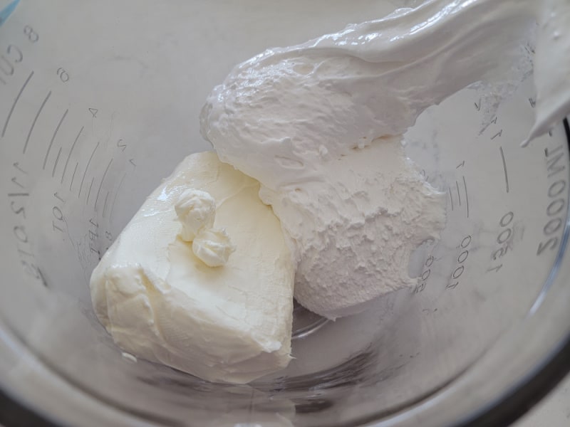 cream cheese and marshmallow cream in a glass bowl 