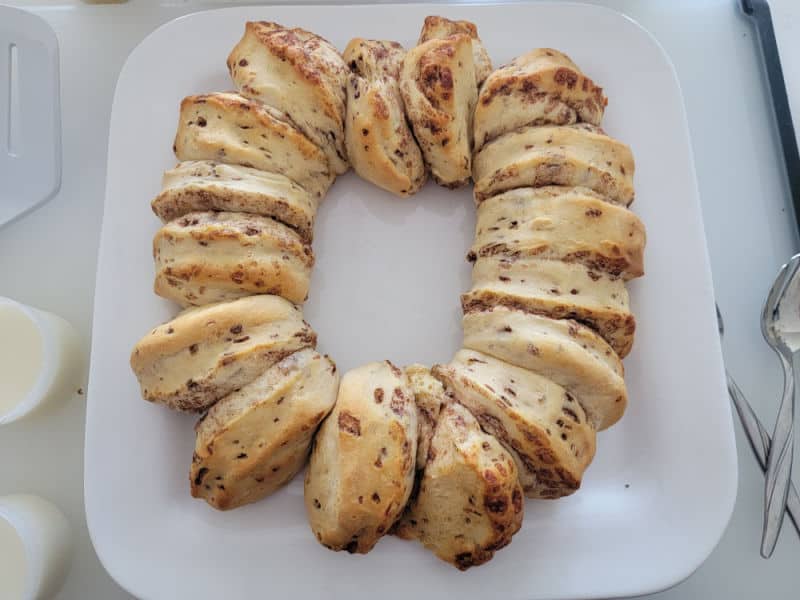 Baked cinnamon rolls in a circle on a white plate