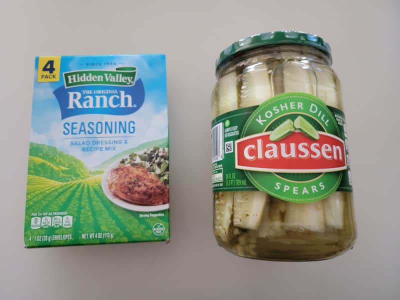Ranch seasoning mix package next to a jar of Claussen pickle spears