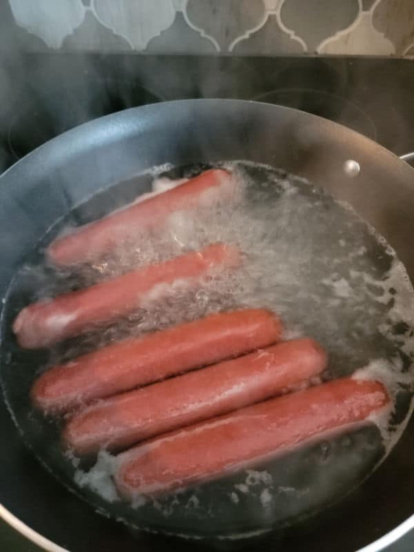 hot dogs boiling in a pan