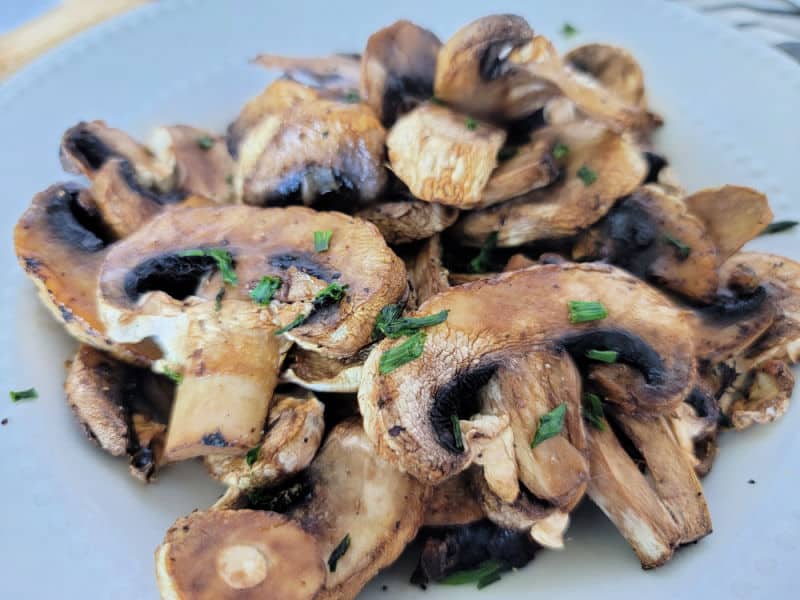 close up of air fried mushrooms on a white plate