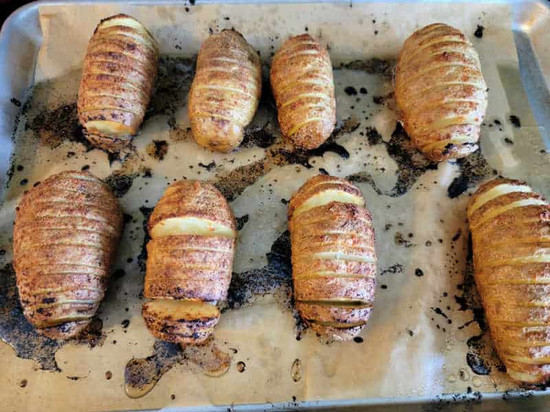 baked hasselback potatoes on parchment paper