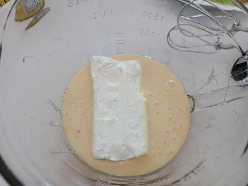 cream cheese and condensed milk in a glass batter bowl 